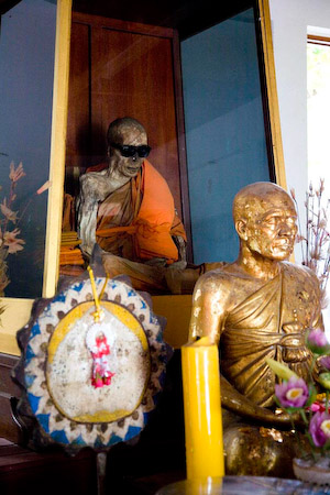 Das ist der "Mummified Monk", ein Mönch, der sich in sitzender Pose und mit Sonnenbrille auf der Nase hat einbalsamieren lassen... Was für uns zum totlachen ist, ist für die Thais aber eine todernste, religiöse Reliquie!